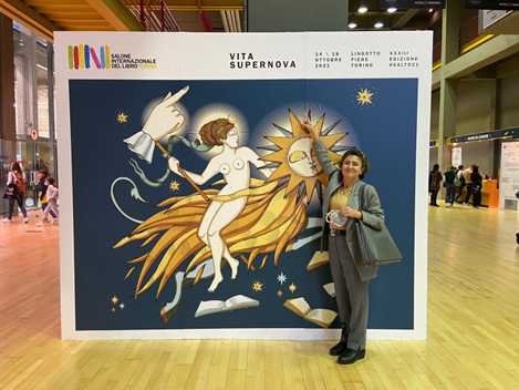 Maria Gravina Ogata em frente ao painel Vita Supernova no Salone del Libro di Torino